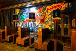 Booths in Unicorn's dining area, with a mural of a phoenix in the background