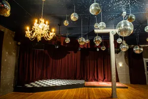 Unicorn's ballroom, showing the stage, velvet curtains, chandelier, and disco balls